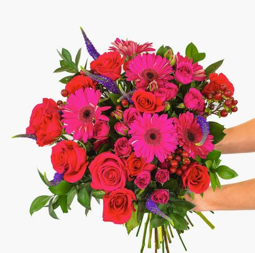 Ce bouquet framboise et bleu révèle un contraste élégant qui attire immédiatement le regard